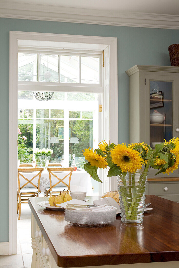 Geschnittene Sonnenblumen in der hellblauen Küche eines Hauses in Tyne & Wear, England, UK