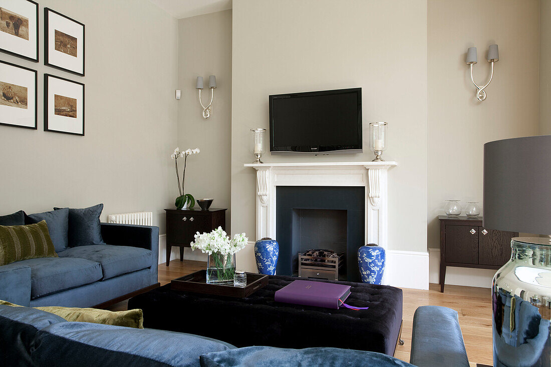 Wall mounted plasma screen above painted fireplace in living room of classic London home, UK