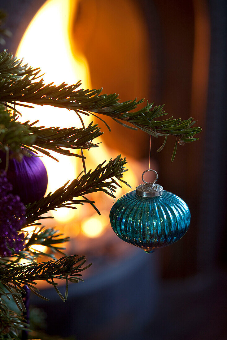 Blaue Metallkugel hängt am Weihnachtsbaum in einem Londoner Haus, UK