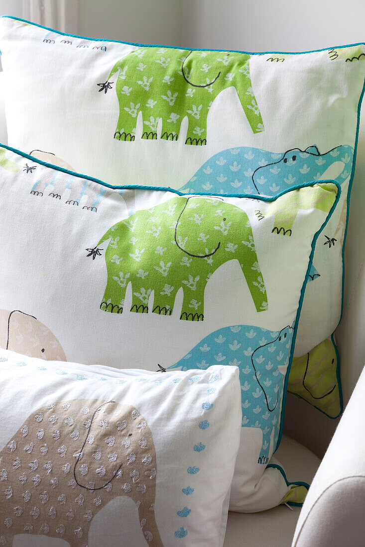 Elephant patterned cushions in childs room of contemporary London home, UK