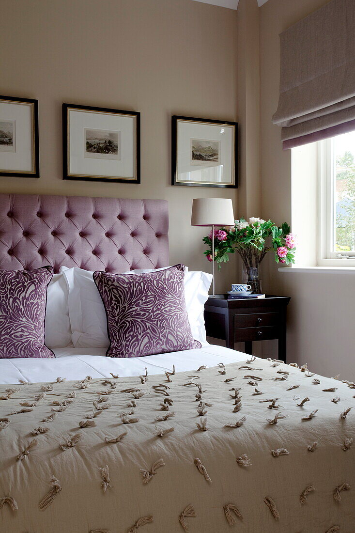 Buttoned headboard and artwork in classic bedroom of contemporary London home, England, UK