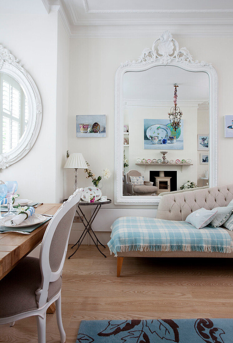 Hellblaue Schottenkaro-Decke auf Chaiselongue mit großem Spiegel im Wohnzimmer eines modernen Hauses in London, UK