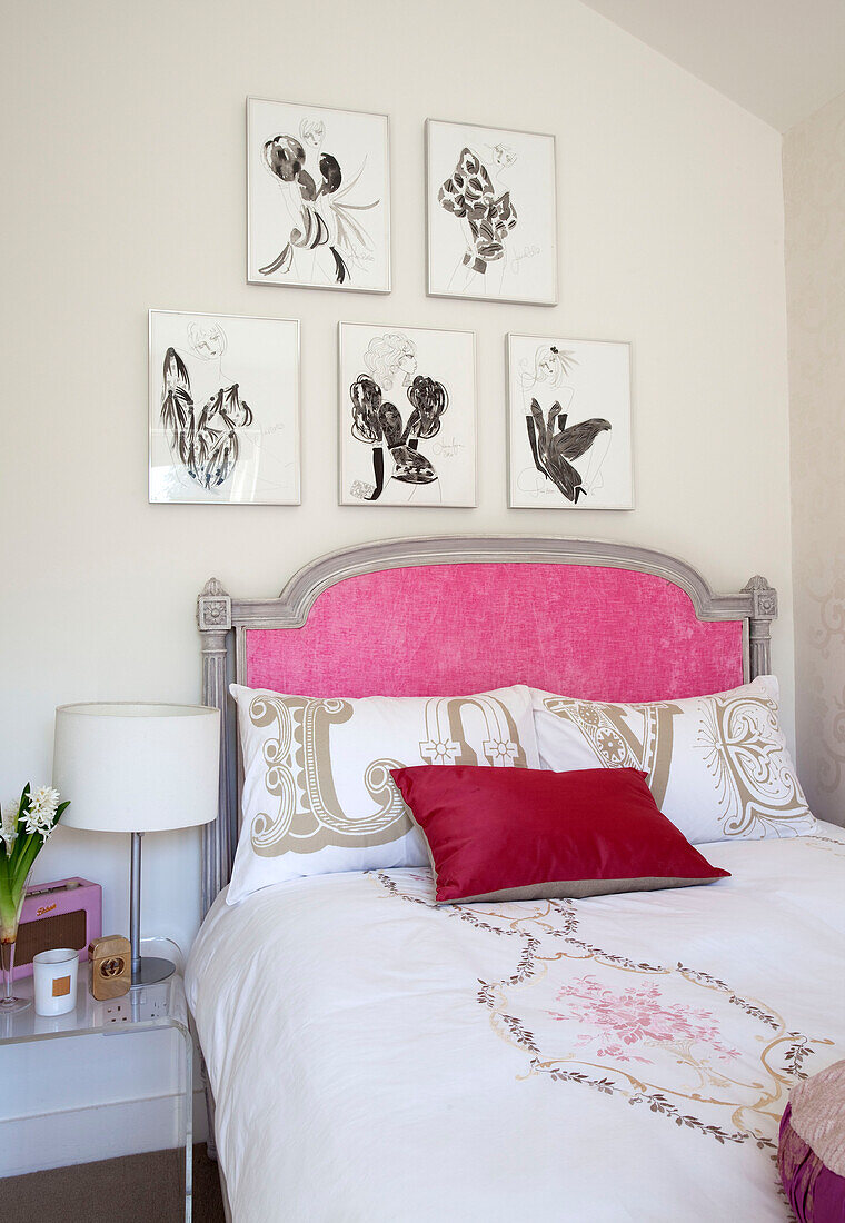 Kunstwerk über einem rosa Kopfteil im Mädchenzimmer eines modernen Londoner Hauses, UK