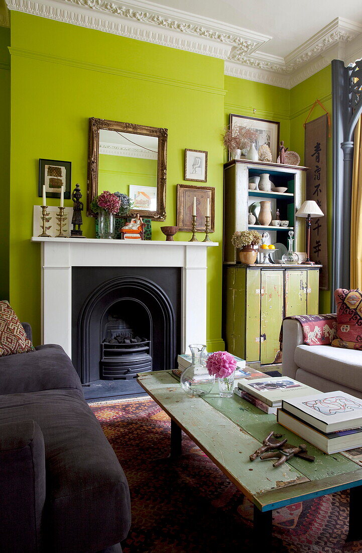 Salvaged coffee table in lime green living room of London home England UK