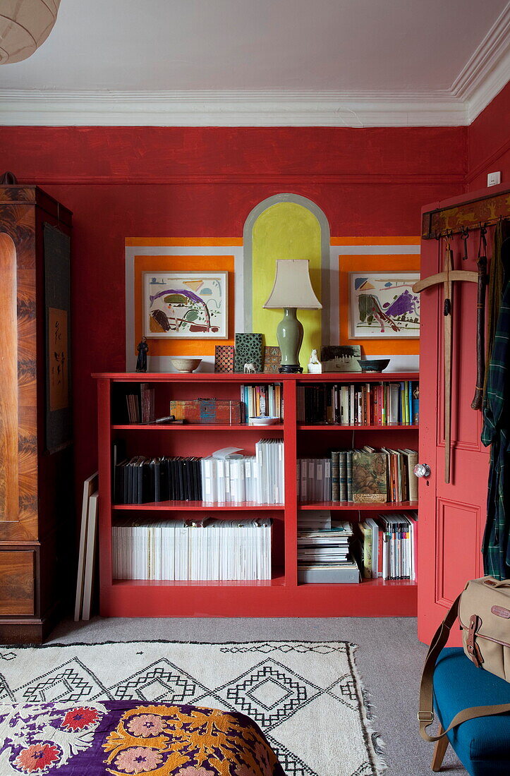 Red shelving unit in bedroom of London home England UK