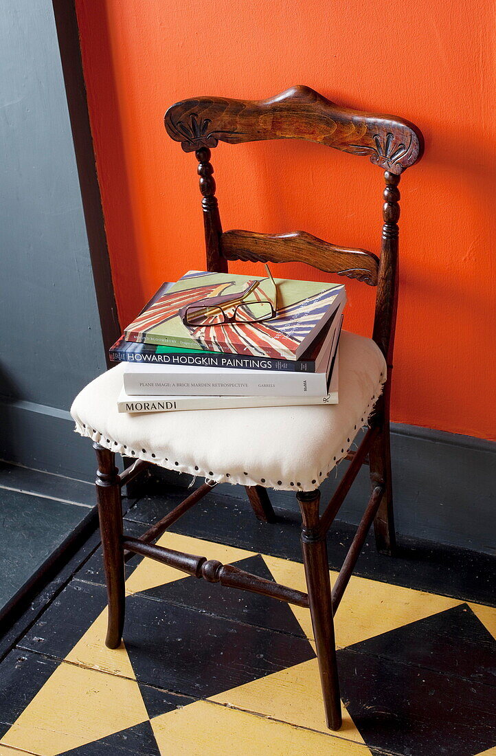 Brillen und Bücher auf einem gepolsterten Stuhl im Flur eines Londoner Hauses England UK