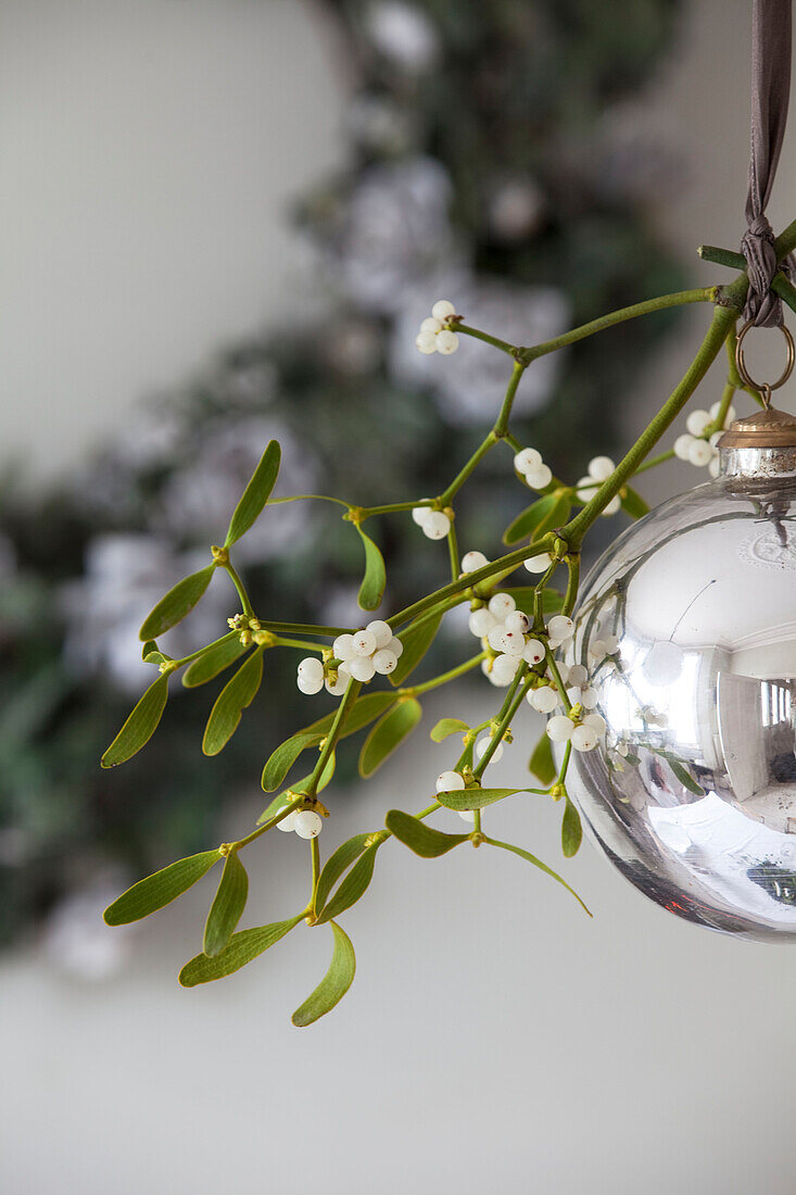Silver bauble with a sprig of mistletoe in London townhouse, England, UK