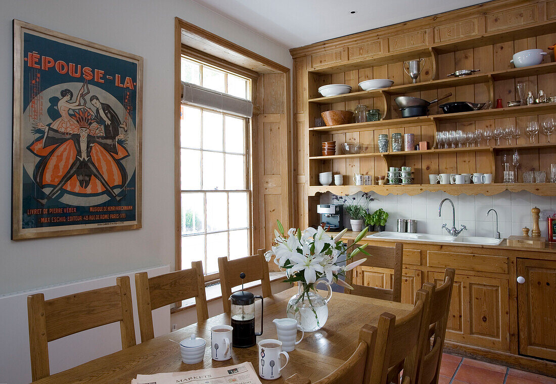Pale wood shelving in London kitchen with French theatre poster