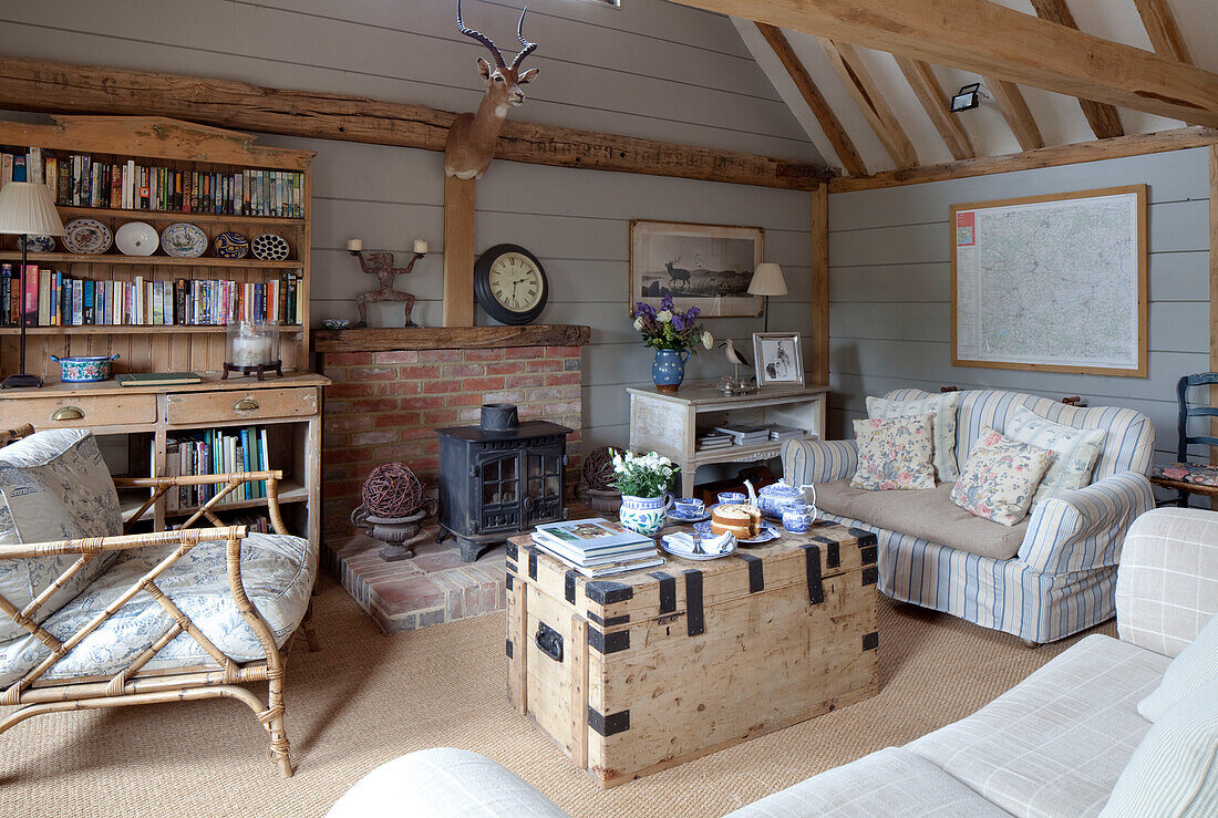Seating area with bookcase in living room of Kent farmhouse England UK