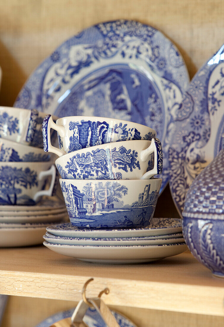 Blaues und weißes Porzellan auf dem Regal einer Küchenkommode in einem Bauernhaus in Kent England UK