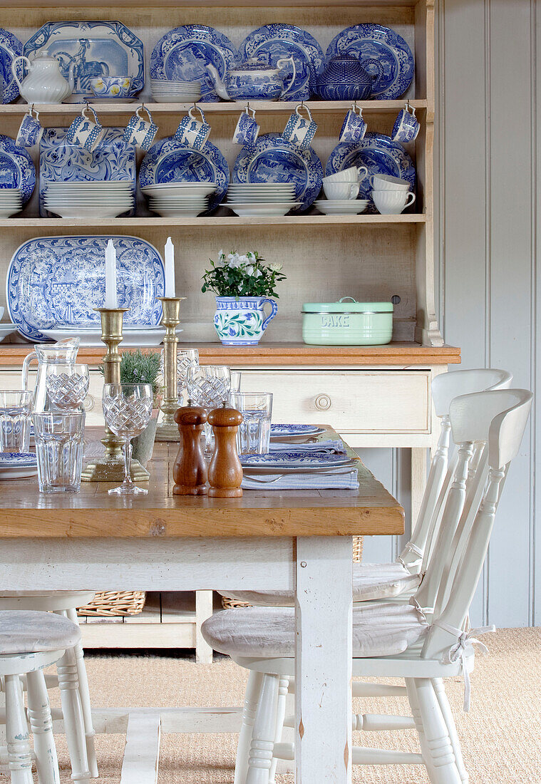 Blaues und weißes Porzellan in einer Kommode mit Gedecken am Tisch in einem Bauernhaus in Kent England UK