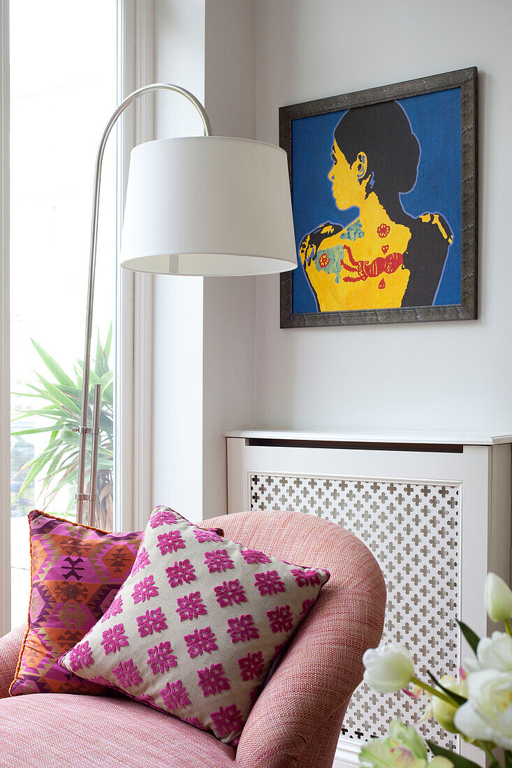 Moderne Kunst und Stehlampe mit doppelarmiger Liege in einem modernen Wohnzimmer in London, UK