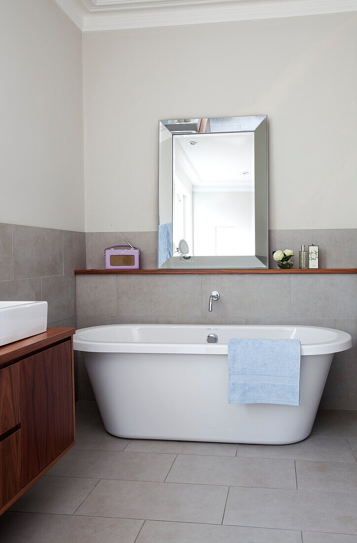 Freistehende Badewanne und Spiegel im Badezimmer eines modernen Londoner Stadthauses, England, UK