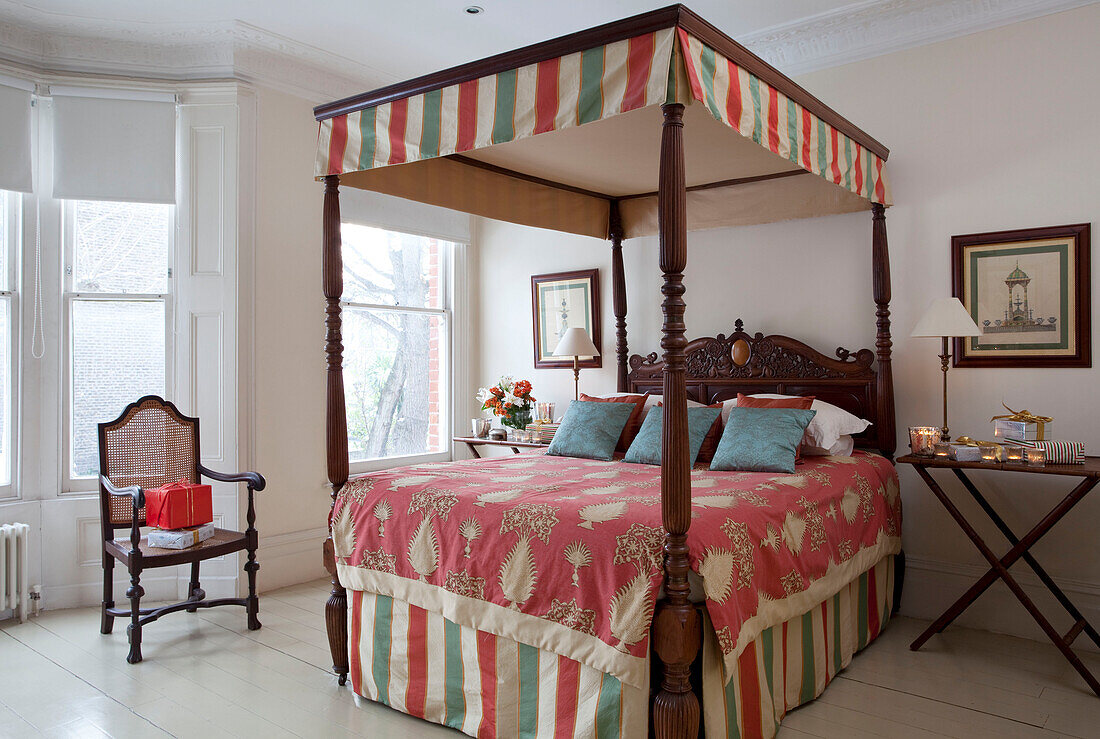 Four poster bed upholstered in contrasting fabrics in London townhouse, UK