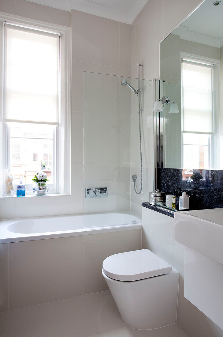 Großer Spiegel mit weißem, sonnenbeschienenem Badezimmer in einer Wohnung in London, UK