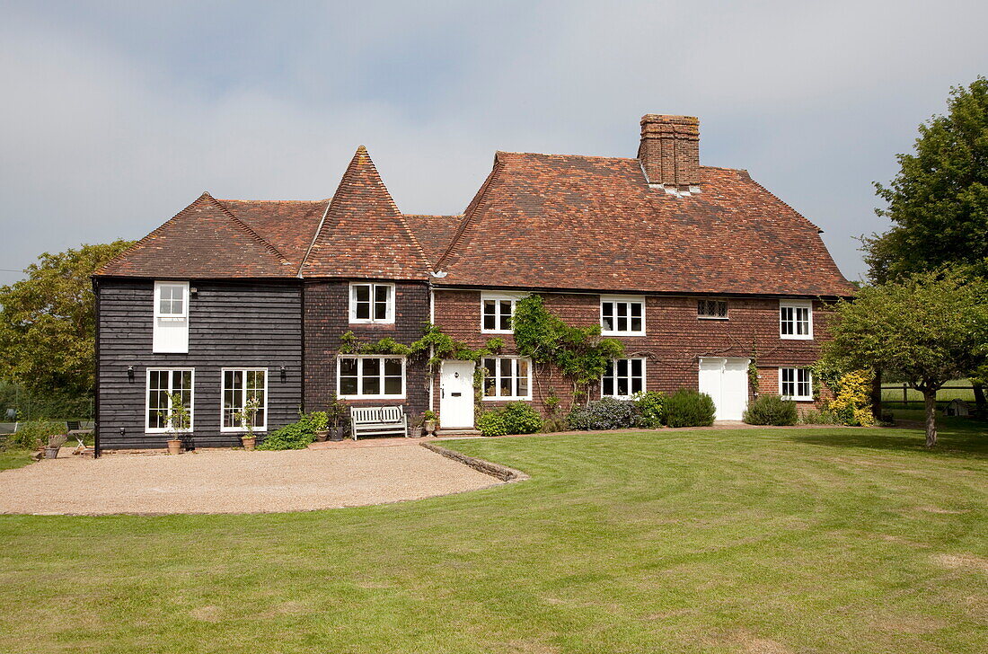 Lawned exterior and driveway to Maidstone farmhouse in Kent, England, UK