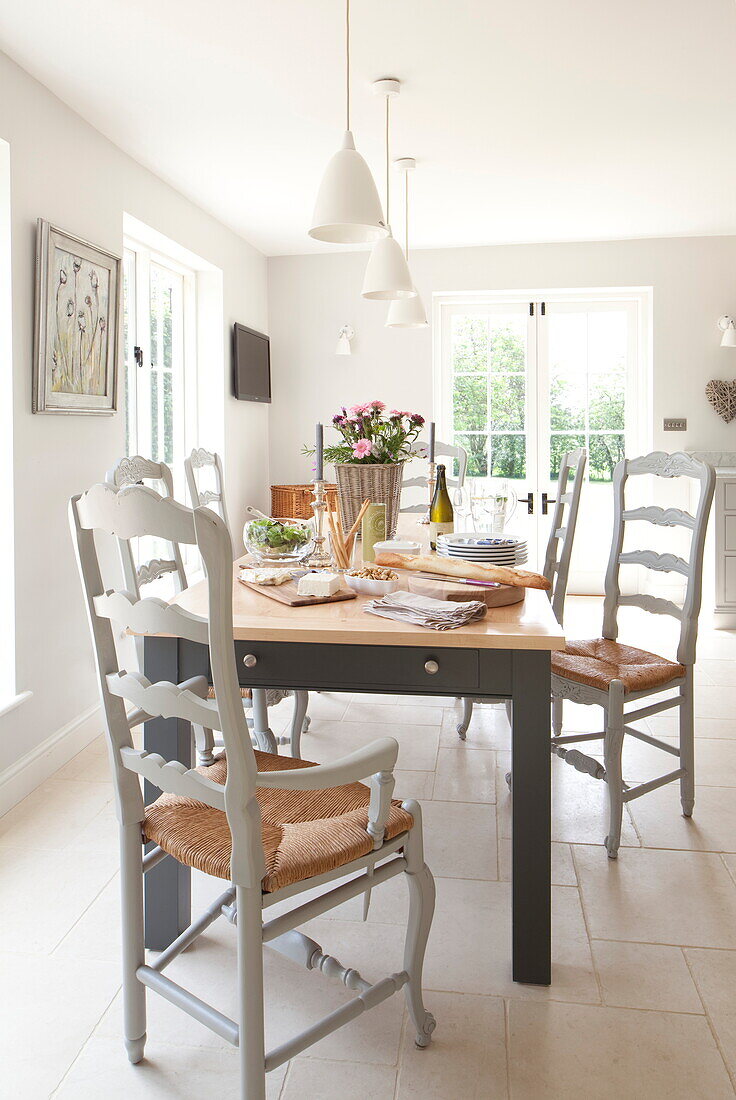 Esstisch mit Korbstühlen in einem modernen Bauernhaus in Maidstone, Kent, England, UK