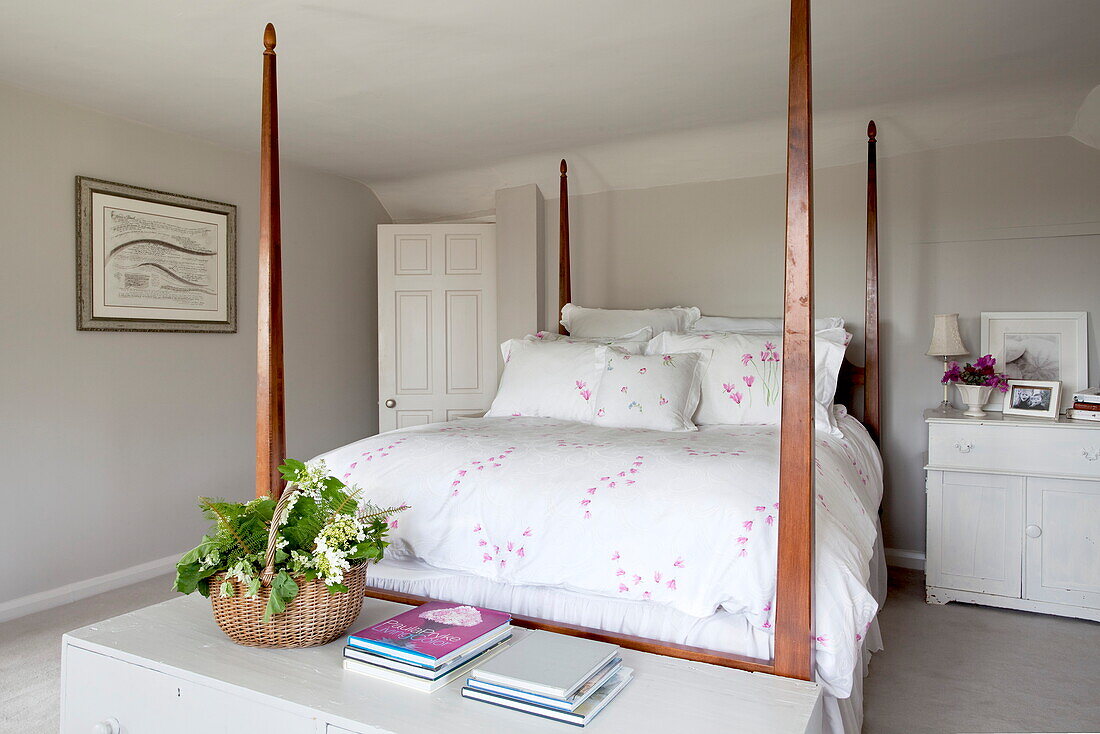 Himmelbett aus Holz mit einem Blumenkorb im Schlafzimmer eines Bauernhauses in Maidstone, Kent, England, UK