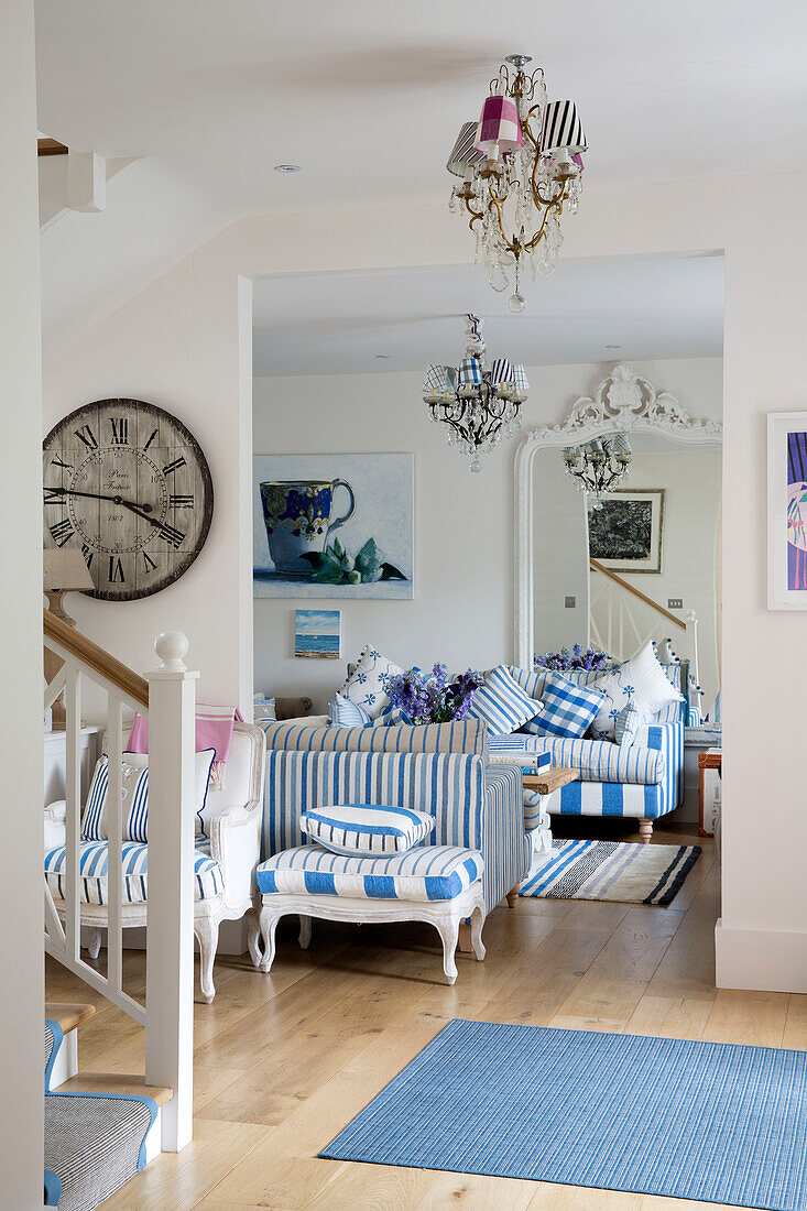 Offenes Wohnzimmer mit gestreiften Sofas und hellblauem Teppich in einem Haus in Dulwich, London, England, UK