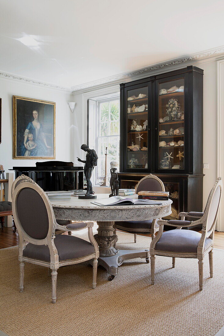 Glasvitrine mit Esstisch und Stühlen aus Marmor in einem historischen Landhaus in Sussex, England, UK
