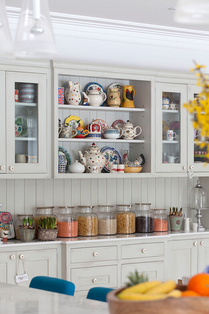 Vorratsgläser und Porzellangeschirr in der Küche eines modernen Landhauses in Surrey, England, UK
