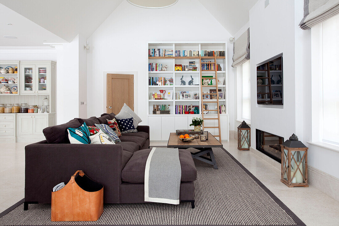 Braunes Sofa und Fußhocker mit Plasmabildschirm im Heimkino eines modernen Landhauses in Surrey, England UK
