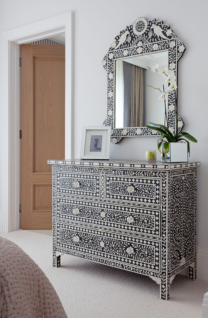 Inlaid chest of drawers and mirror frame in bedroom detail of contemporary Surrey country home England UK