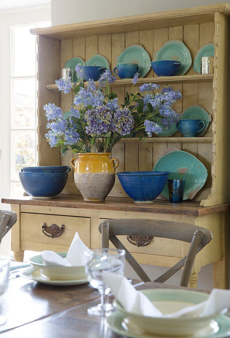 Blue ceramic tableware on kitchen dresser in dining room of Sussex home England UK