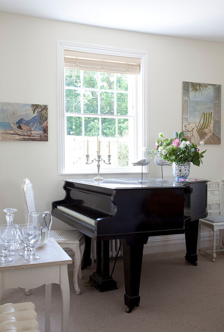 Baby grand piano at window of coastal Sussex cottage, England, UK