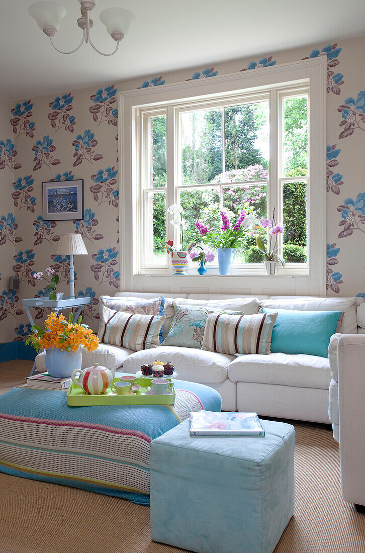 Hellblaue Fußhocker im Wohnzimmer mit Blümchentapete, Landhaus in Sussex, England, UK