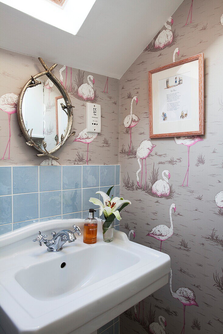 Tapete mit Flamingodruck und Waschbecken mit blauen Kacheln in einem Haus in London, England, Vereinigtes Königreich