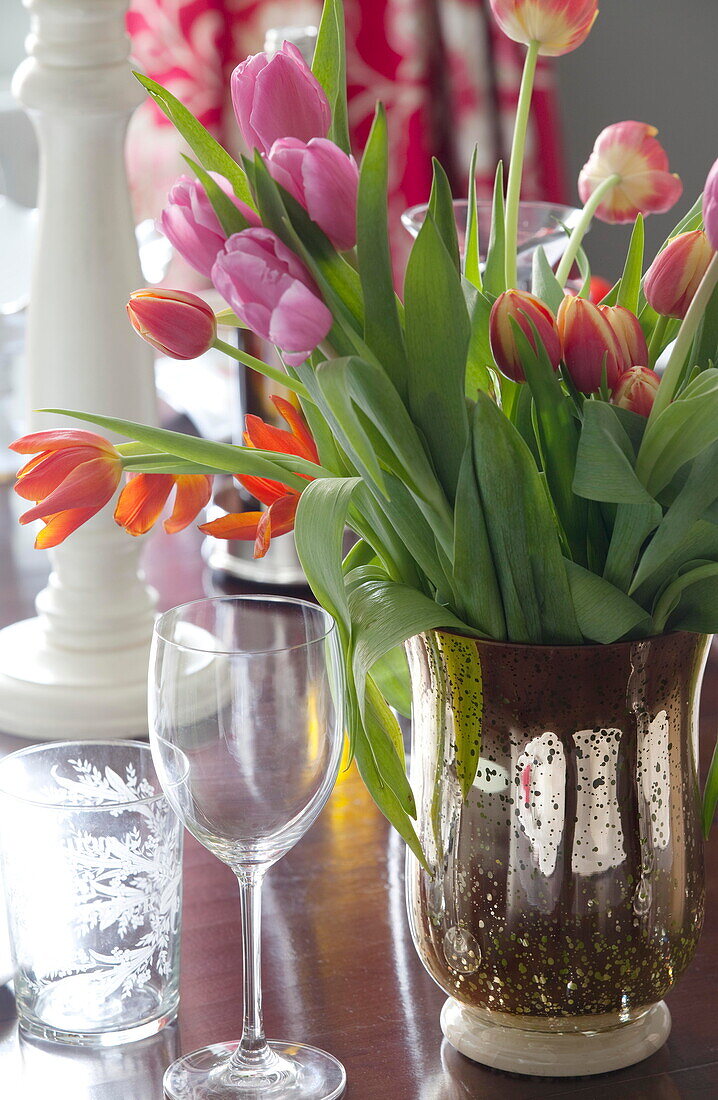 Geschnittene Tulpen und Weingläser auf einem Esstisch in einem Bauernhaus in Staffordshire, England UK