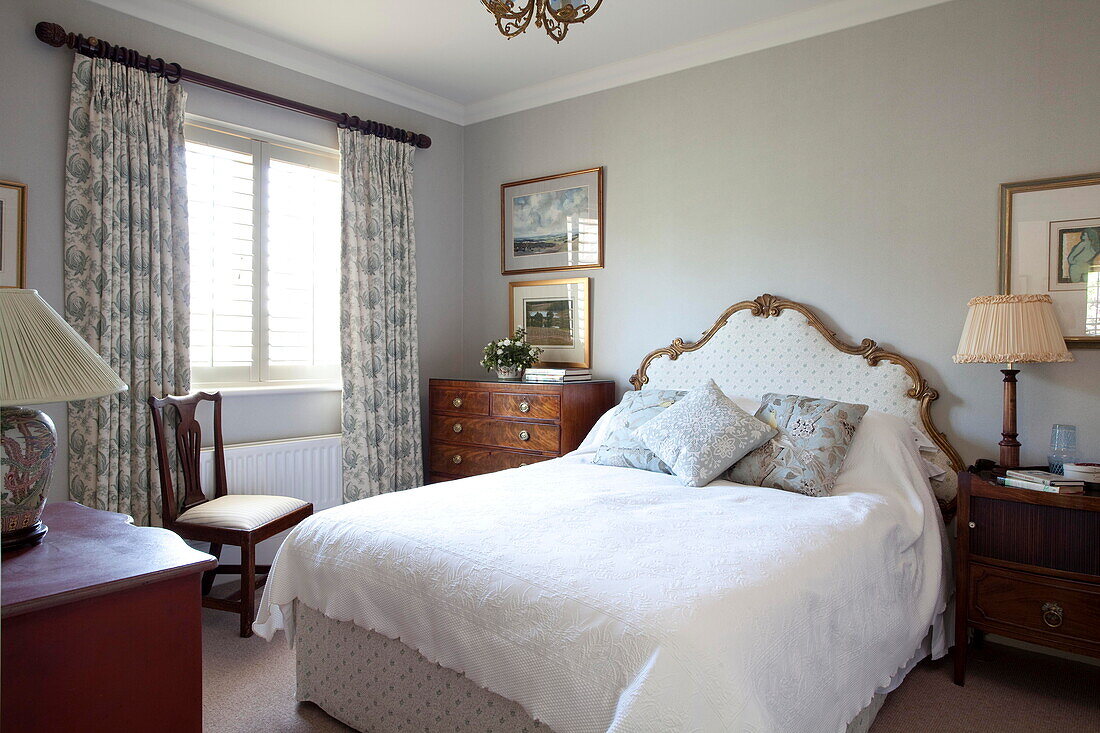 Vergoldetes Kopfteil auf einem Bett mit weißem Bezug in einem Haus in Kent, England, Vereinigtes Königreich