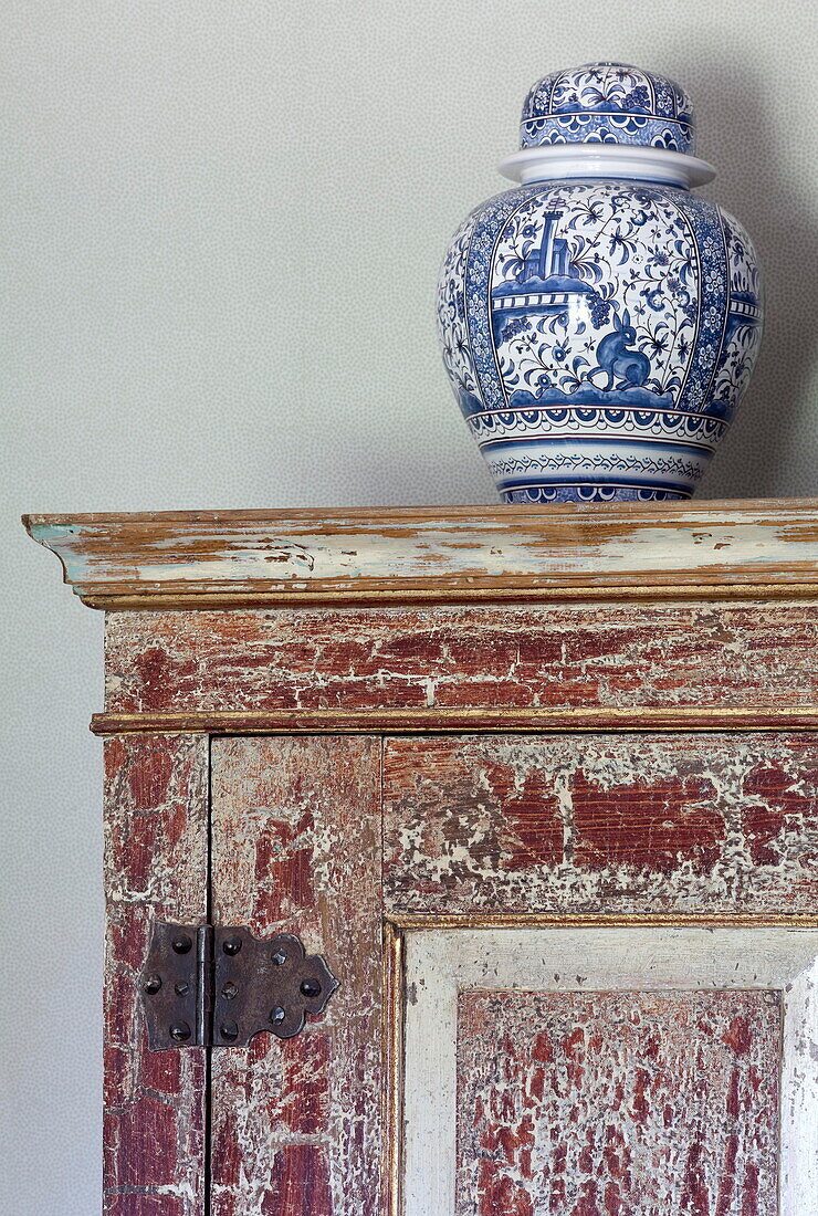 Blue and white chinaware urn on salvaged cabinet in Kent home England UK