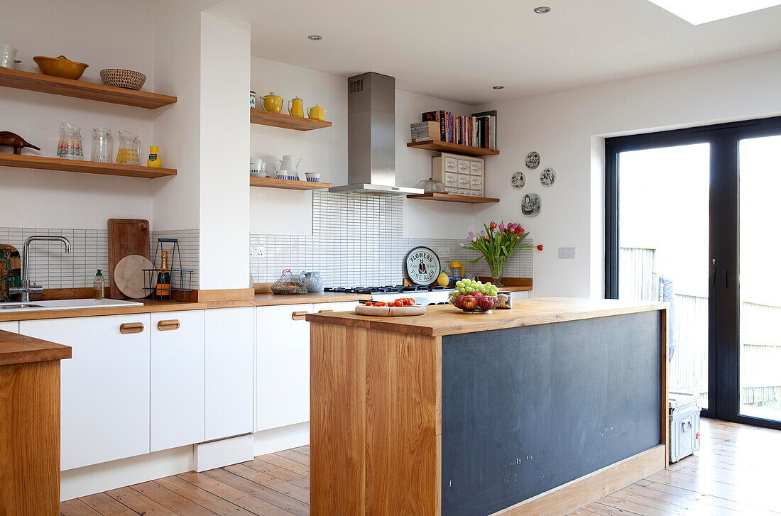 Kücheninsel mit Tafelfarbe und offenen Regalen in einem Einfamilienhaus in Kent, England, UK