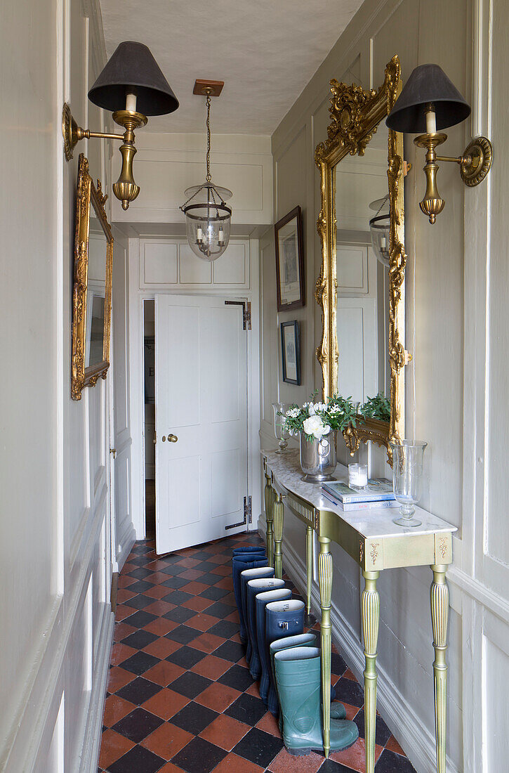 Gilt-framed mirrors in terracotta hallway with console in Wells next the Sea, Norfolk, England, UK