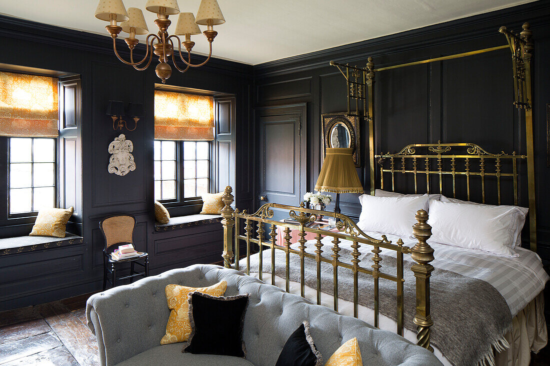 Brass bed in black panelled bedroom of Wells next the Sea home Norfolk England UK