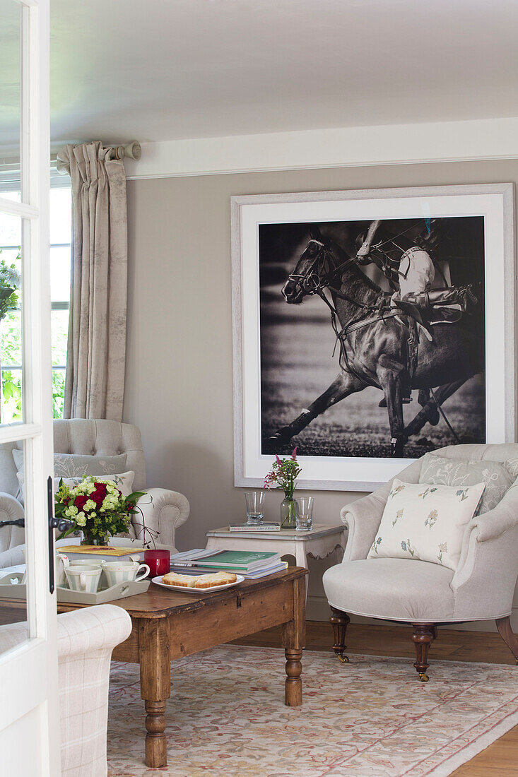 Großer Schwarz-Weiß-Druck mit Sessel im Wohnzimmer eines Hauses in Sussex Downs, England, UK