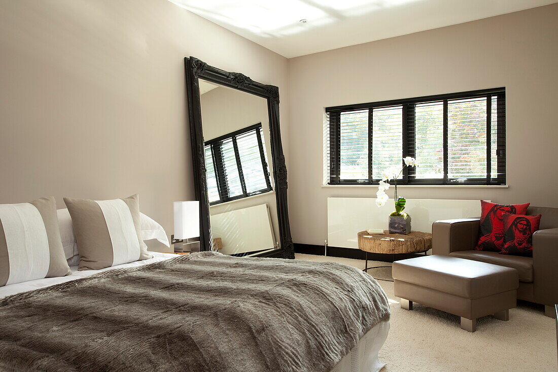 Pelzdecke auf dem Bett mit großem Spiegel in einem modernen Haus, Kingston upon Thames, England, UK
