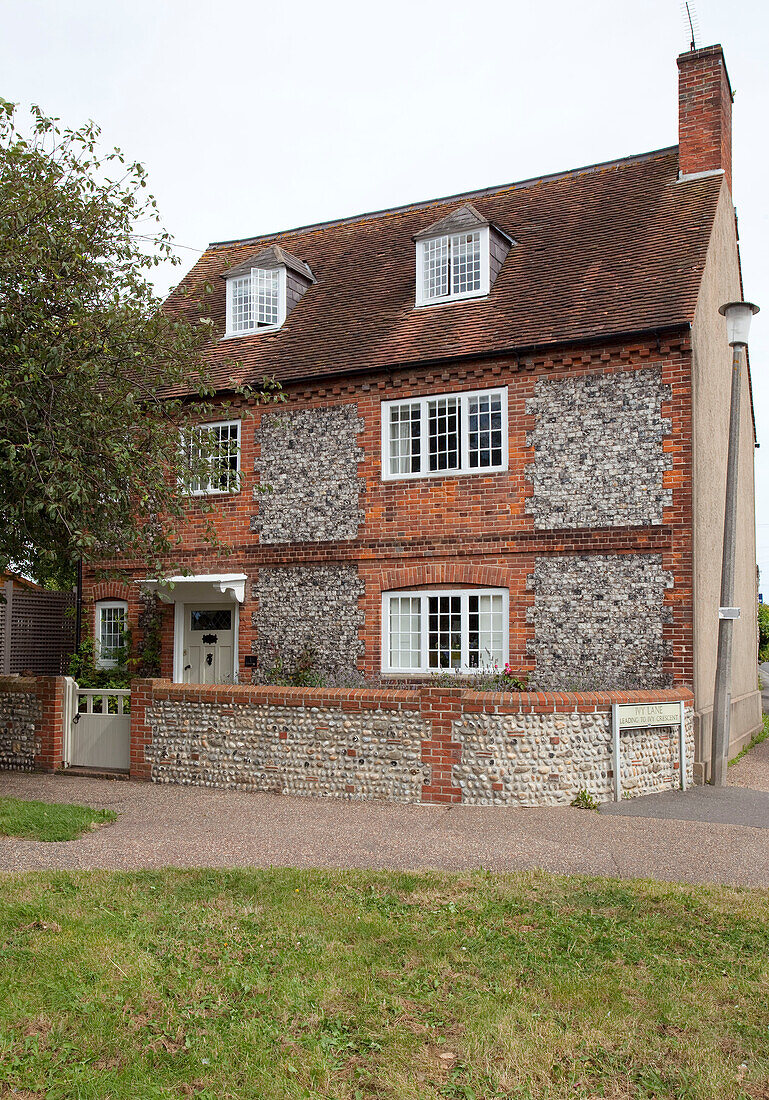 Dreigeschossige Fassade aus Kieselstein und Ziegeln eines Einfamilienhauses in West Sussex, England, Vereinigtes Königreich