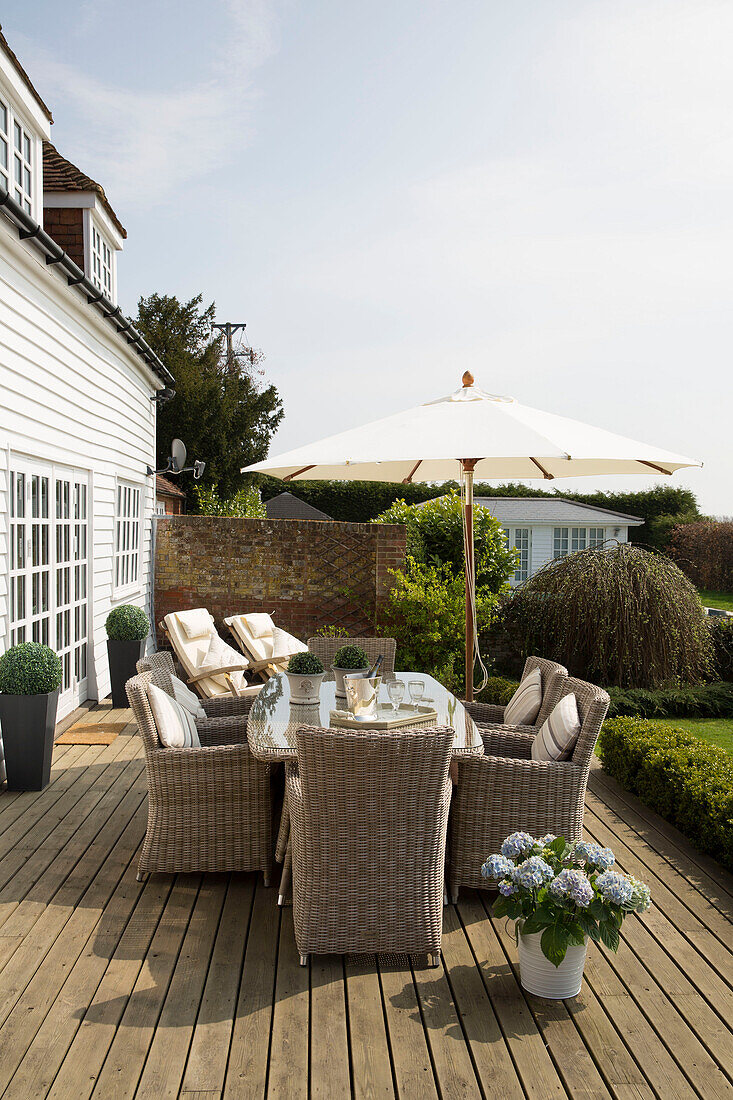 Wicker garden furniture with parasol on terrace of West Maling home, Kent, England, UK
