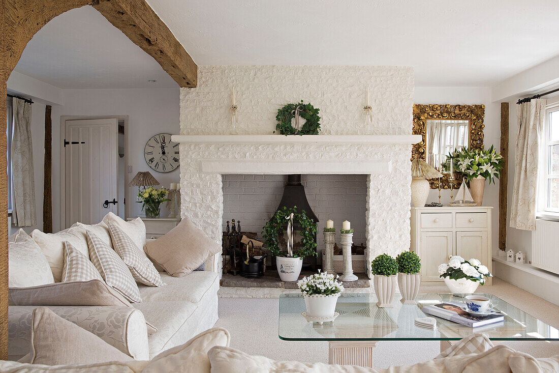 Weißes Sofa mit gläsernem Couchtisch im weißen Wohnzimmer eines Hauses in West Mailing, Kent, England, UK