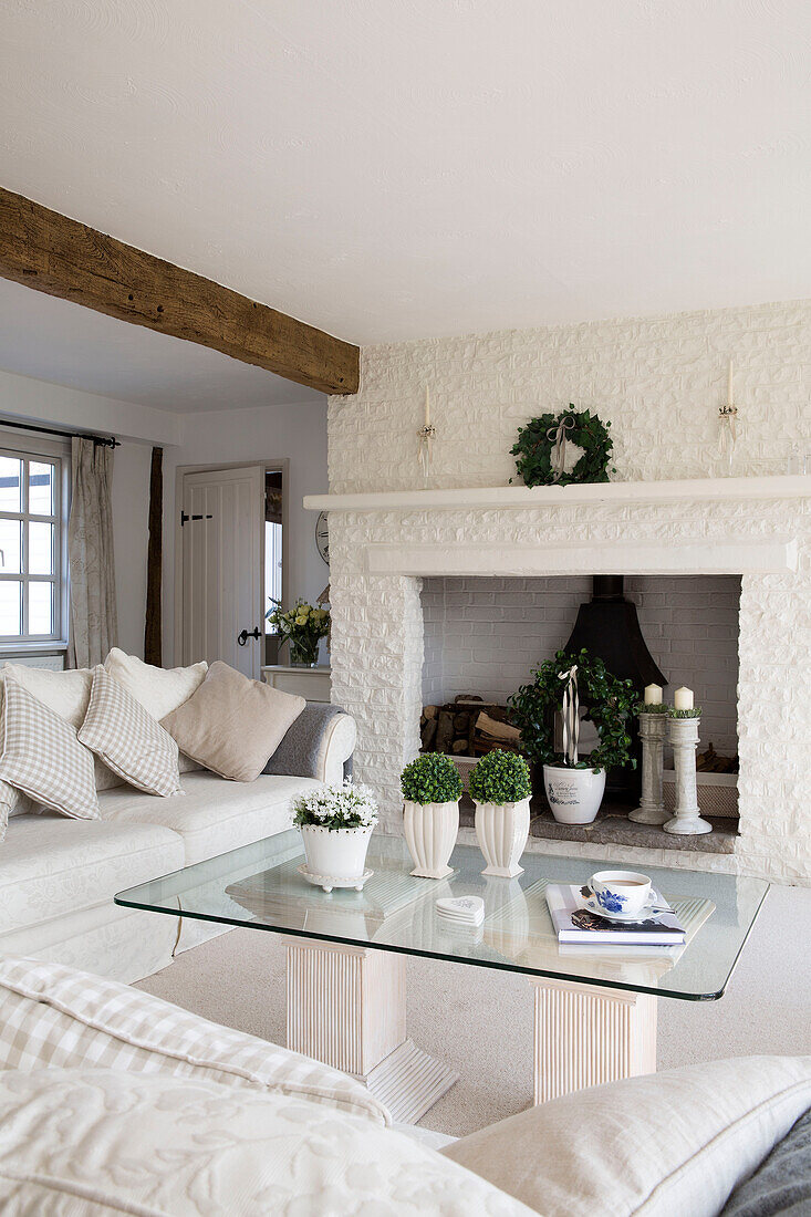 Glass-topped coffee table in whitewashed living room of West Mailing home, Kent, England, UK