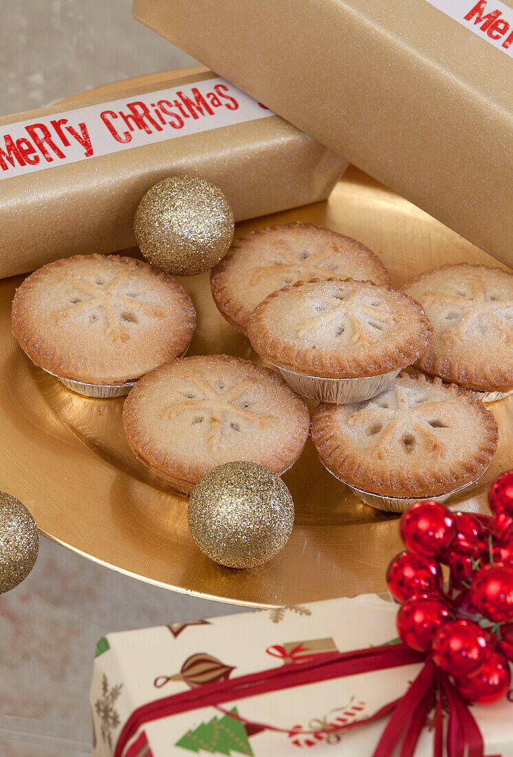 Mince pies with baubles and Christmas gifts in West Sussex home, England, UK