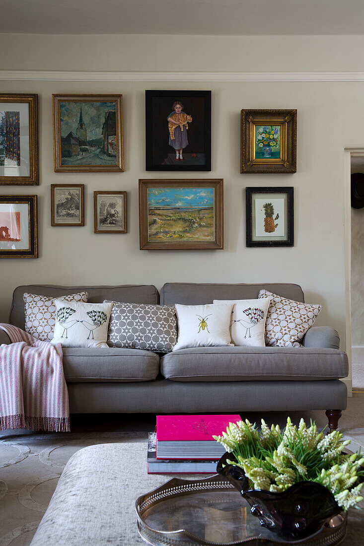 Gerahmtes Kunstwerk über grauem Sofa im Wohnzimmer eines Hauses in London England UK