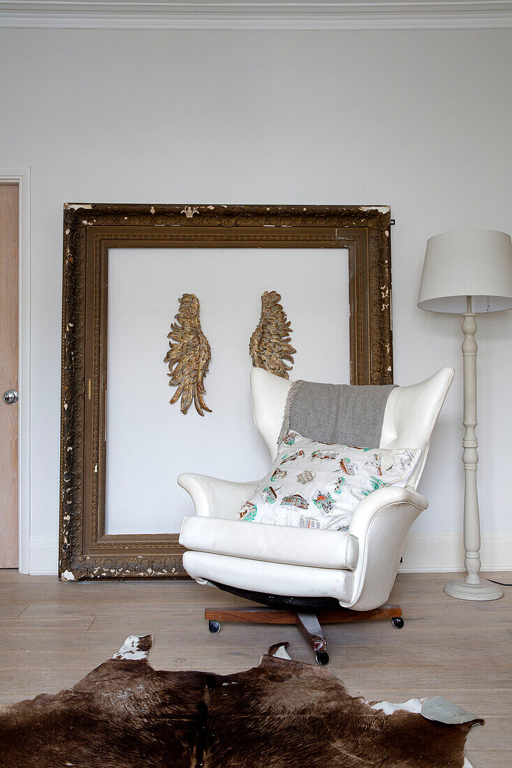 White leather armchair with vintage picture frame in living room of London townhouse, England, UK