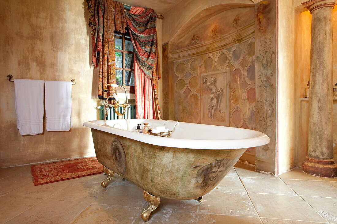 Freestanding bath with frescos and window fabric in French holiday villa