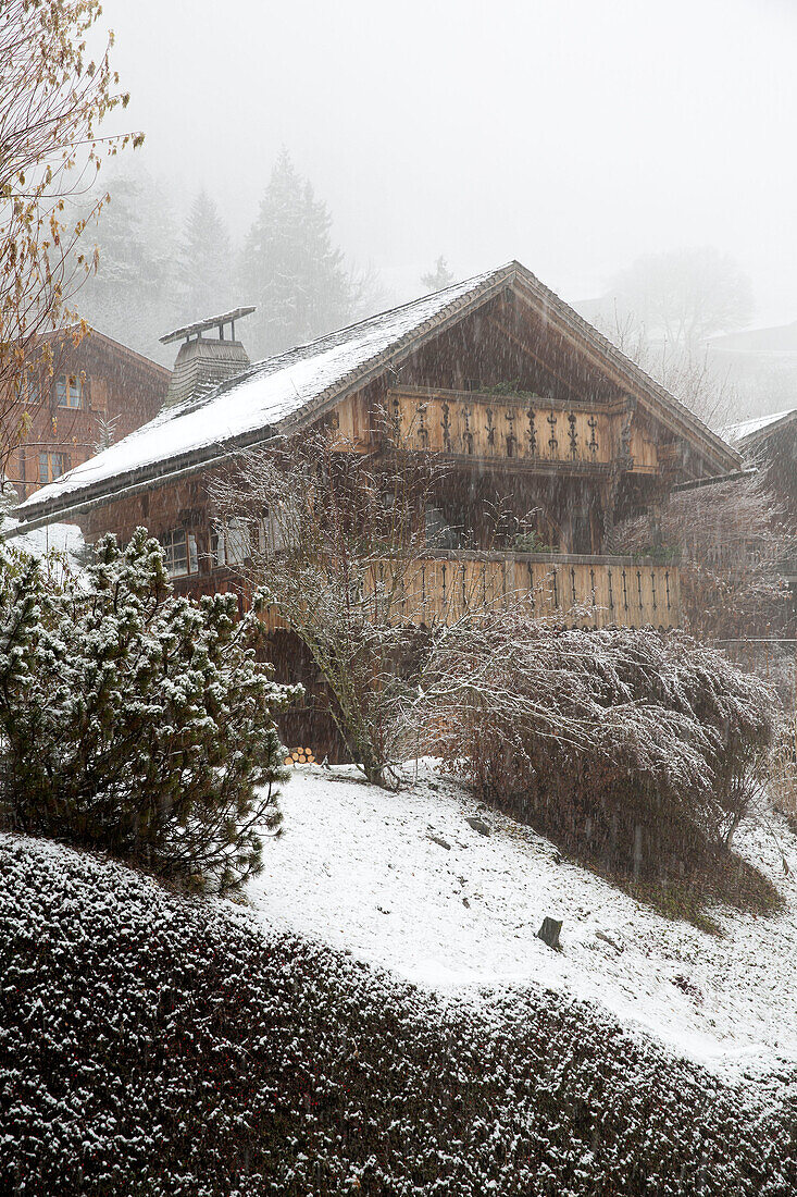 Wooden mountain chalet in snow blizzard, Chateau-d'Oex, Vaud, Switzerland