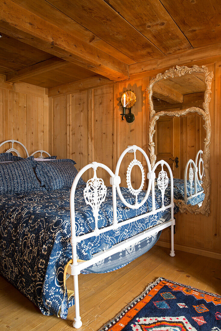 Weißes Schmiedeeisenbett in holzgetäfeltem Zimmer, Bergchalet, Chateau-d'Oex, Waadt, Schweiz