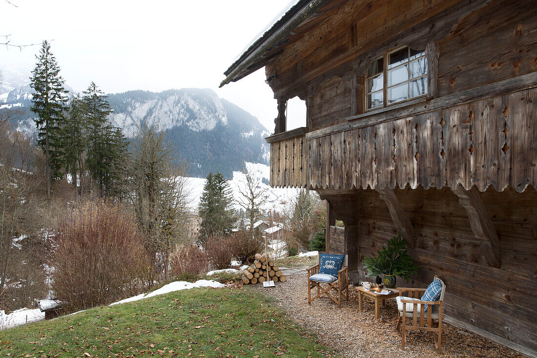 Folding chairs under balcony exterior of mountain chalet in Chateau-d'Oex, Vaud, Switzerland